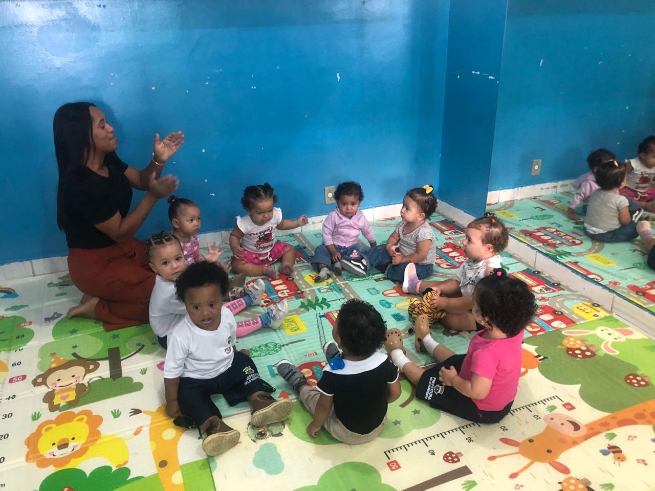 Bebés do berçário em roda de música com a educadora